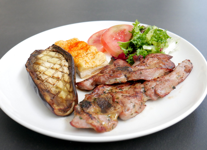 Chuleta de pavo marinada a la plancha con berenjena asada, hummus y ensalada