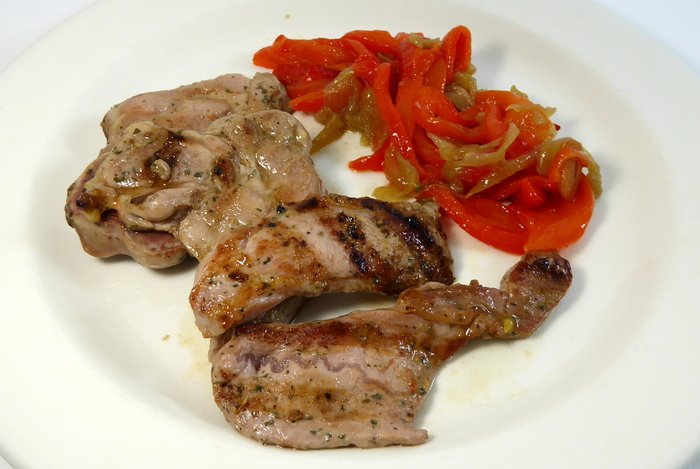 Grilled turkey chop with stewed red peppers and onions